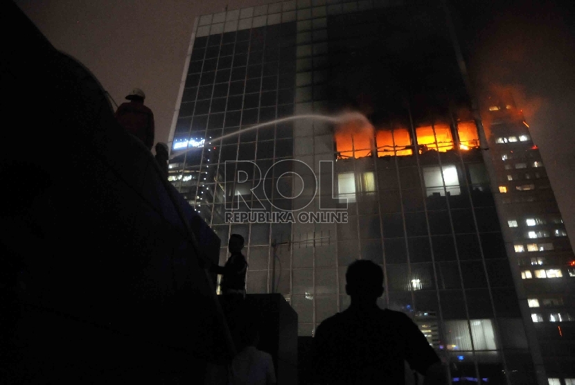 Pemadam kebakaran berusaha memadamkan kebakaran di Gedung Wisma Kosgoro, Jalan Thamrin, Jakarta Pusat, Senin (9/3).  (Republika/Agung Supriyanto)