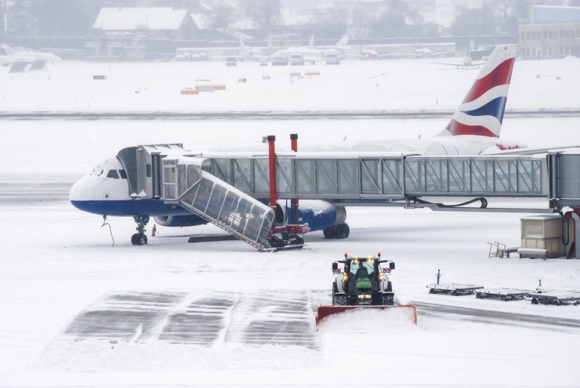 Pemadam kebakaran dari Airport Security Services (SSA) membersihkan salju dari landasan di Bandara Jenewa di Switzerland, Kamis (1/3). 