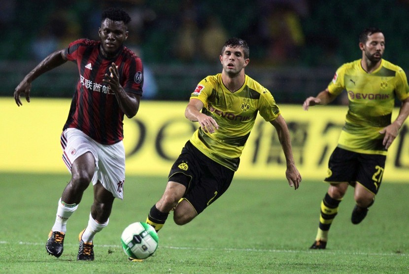 Pemain AC Milan Franck Kessie (kiri) berebut bola dengan dua pemain Borussia Dortmund, Christian Pulisic dan Gonzalo Castro, pada laga International Champions Cup (ICC) di Stadion Universitas Town Sports Centre, Guangzhou, Cina, 18 Juli 2017.