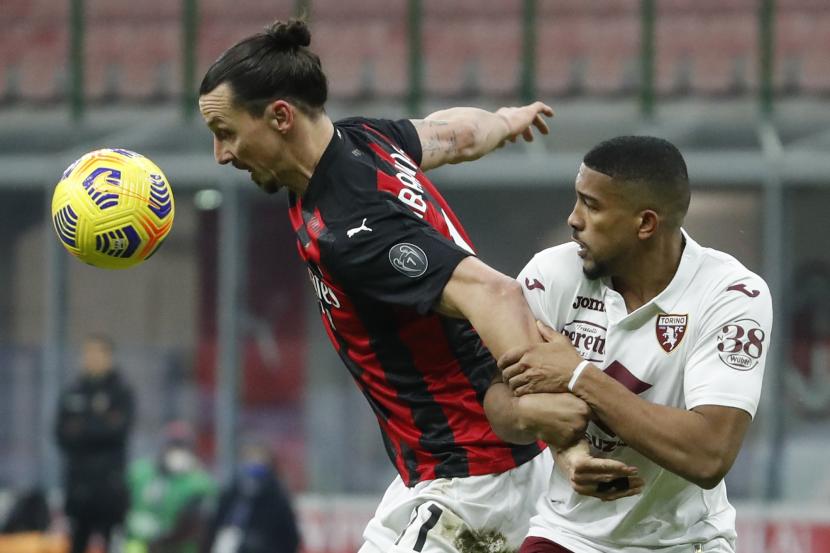 Pemain AC Milan Zlatan Ibrahimovic, kiri, ditantang oleh Gleison Bremer dari Torino saat pertandingan babak 16 besar Piala Italia antara AC Milan dan Torino di stadion San Siro, di Milan, Italia, Selasa, 12 Januari 2021. 