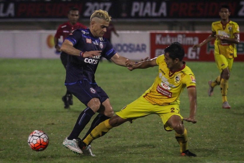 Pemain Arema FC, Cristian Gonzales (kiri) berebut bola dengan pemain Sriwijaya FC, Firdaus Ramadhan (kanan) pada pertandingan perempat final Piala Presiden 2017 di Stadion Manahan, Solo, Ahad (26/2).