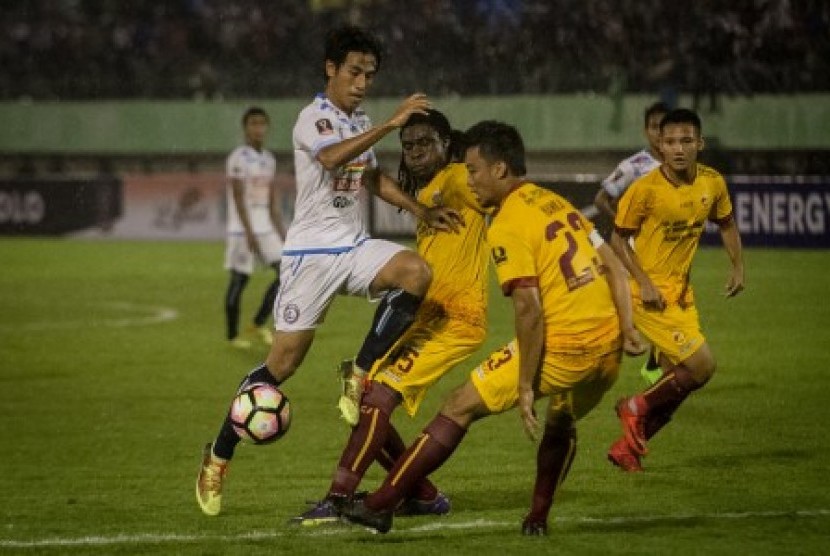 Pemain Arema FC Hanif Sjahbani berusaha melewati hadangan dua pemain Sriwijaya FC Bio Paulin dan Hamka Hamzah pada Pertandingan Perempat Final Piala Presiden 2018 di Stadion Manahan, Solo, Jawa Tengah, Ahad (4/2). 