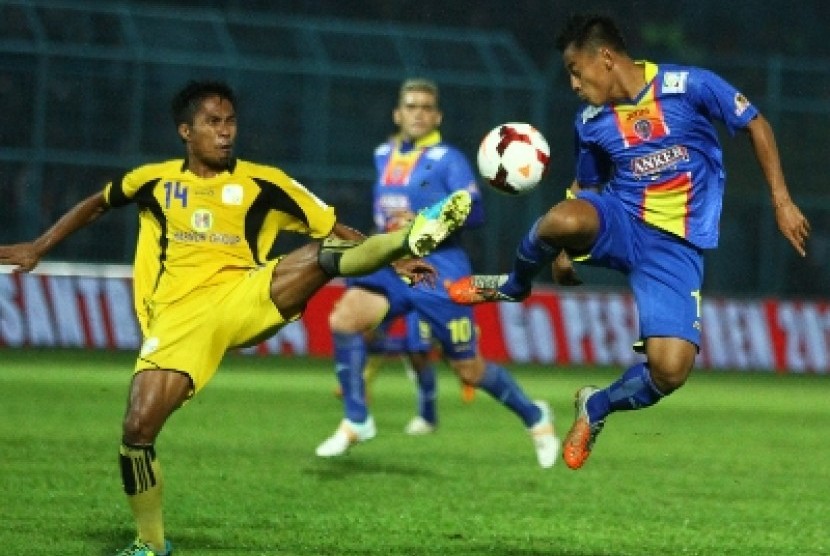 Pemain Arema Indonesi Cronous, Samsul Arif (kanan) berebut bola dengan pesepakbola Barito Putra, Faturrahman.