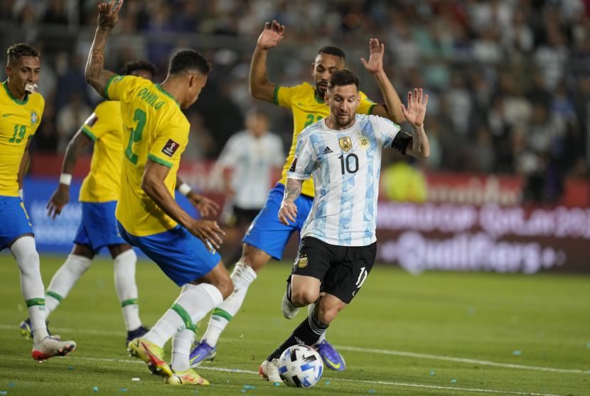 Pemain Argentina Lionel Messi melarikan diri dengan bola dari pemain Brasil Matheus Cunha, punggung, dan Danilo selama pertandingan sepak bola kualifikasi untuk Piala Dunia FIFA Qatar 2022 di stadion Bicentenario di San Juan, Argentina, Rabu (17/11).