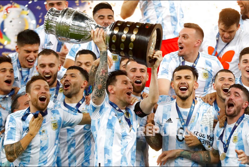 Pemain Argentina Lionel Messi (tengah) mengangkat trofi juara Copa America 2021 setelah Argentina berhasil mengalahkan Brasil pada laga final Copa America 2021 di Stadion Maracana, Ahad (11/7).  