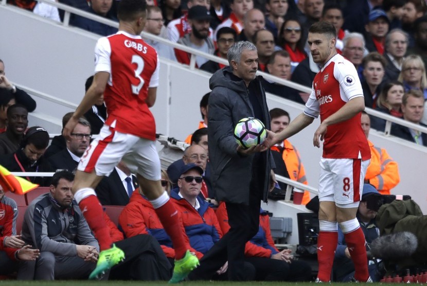 Pemain Arsenal Aaron Ramsey (kanan) mengambil bola dari Manajer Manchester United Jose Mourinho dalam pertandingan Liga Inggris antara Arsenal dan Manchester United, (7/5).