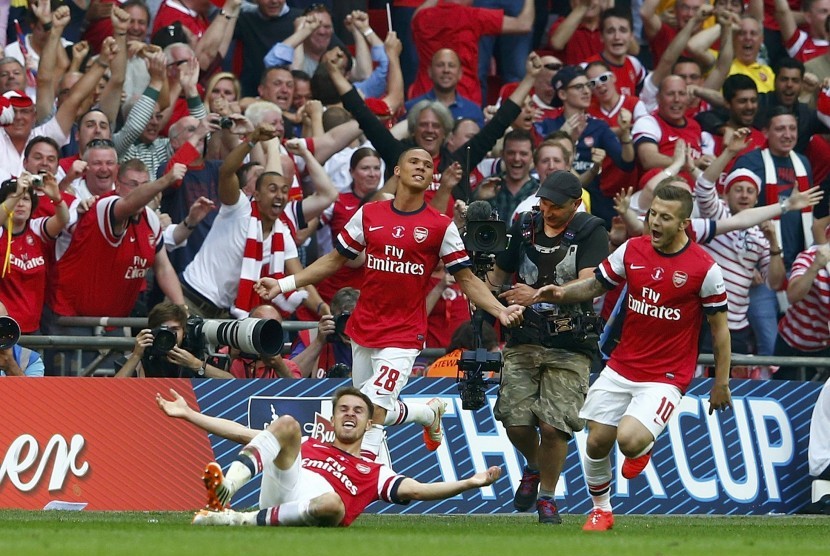 Pemain Arsenal, Aaron Ramsey (kiri), melakukan selebrasi bersama rekan setimnya usai menjebol gawang Hull City di final Piala FA di Stadion Wembley, London, Sabtu (17/5). 