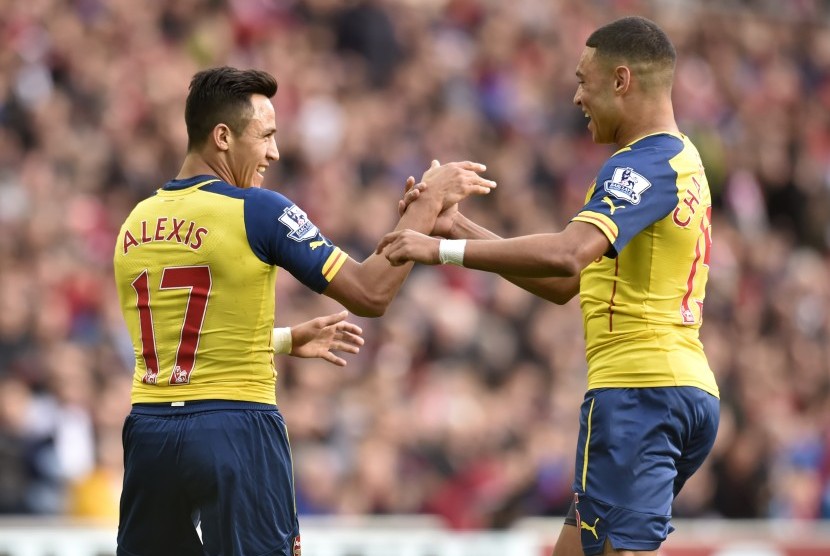 Pemain Arsenal Alexis Sanchez (kiri) bersama Alex Oxlade-Chamberlain merayakan gol ke gawang Sunderland, Sabtu (25/10).