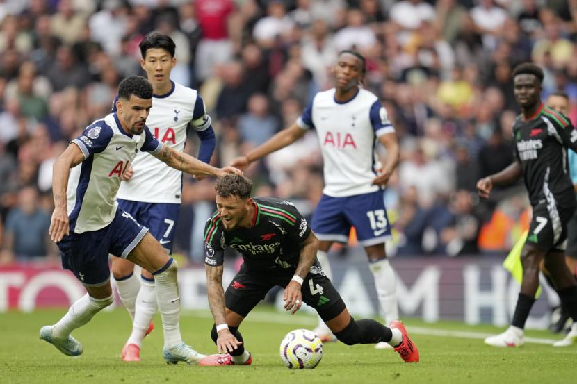 Pemain Arsenal Ben White terjatuh setelah ditantang pemain Tottenham Dominic Solanke selama pertandingan sepak bola Liga Primer Inggris antara Tottenham Hotspur dan Arsenal di London, Ahad, 15 September 2024