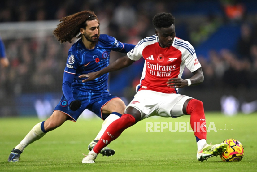 Pemain Arsenal Bukayo Saka (kanan) beraksi menghadapi bek Chelsea Marc Cucurella dalam pertandingan Liga Primer Inggris di Stamford Bridge, London yang berakhir Senin (11/11/2024) dini hati WIB. Arsenal ditahan imbang Chelsea 1-1.