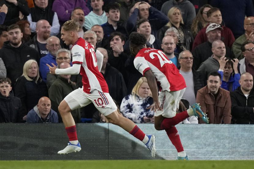 Pemain Arsenal Emile Smith Row, kiri, merayakan setelah mencetak gol kedua timnya selama pertandingan sepak bola Liga Inggris antara Chelsea dan Arsenal di Stamford Bridge di London, Rabu, 20 April 2022.
