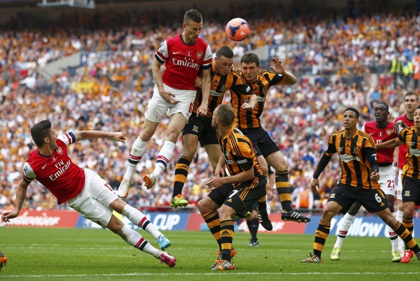 Pemain Arsenal, Laurent Koscielny (dua kiri), loncat melepaskan sundulan saat menghadapi Hull City di final Piala FA di Stadion Wembley, London, Sabtu (17/5). 