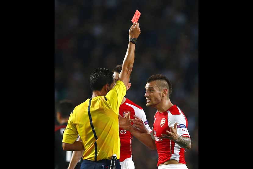 Pemain Arsenal, Mathieu Debuchy (kanan), diusir keluar lapangan oleh wasit Pedro Proenca saat menghadapi Besiktas di leg kedua babak playoff Liga Champions di Stadion Emirates, London, Rabu (27/8). 