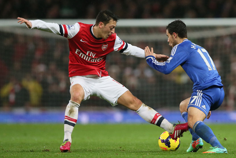 Pemain Arsenal Mesut Ozil (kiri) berusaha menghadang pemain Chelsea Eden Hazard pada pertandingan Liga Inggris di Stadion Emirates,London Senin (23/12).