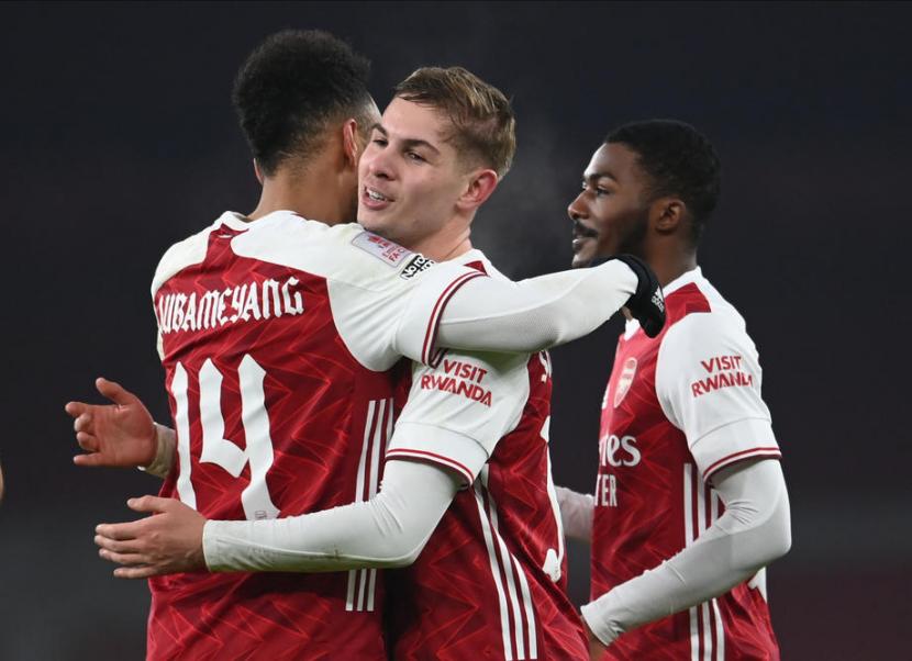 Pemain Arsenal, Pierre-Emerick Aubameyang (kiri), memeluk rekannya Emile Smith Rowe usai mencetak gol ke gawang Newcastle United dalam laga putaran ketiga Piala FA di London pada Sabtu (9/1). 