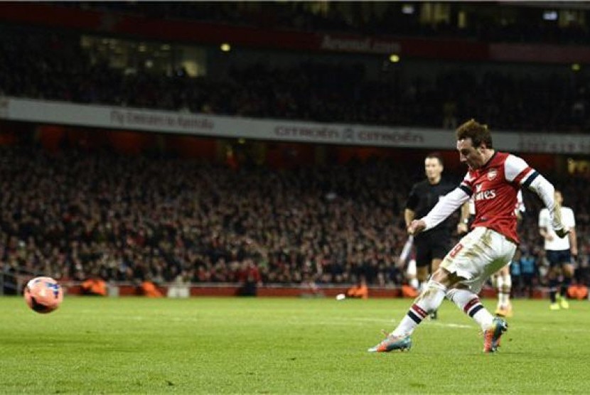 Pemain Arsenal, Santi Cazorla (kanan), melepaskan tembakan menjebol gawang Tottenham Hotspur dalam laga putaran ketiga Piala FA di Stadion Emirates, London, Sabtu (4/1). 