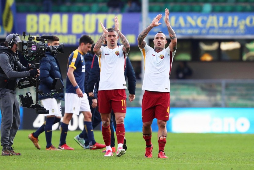 Pemain AS Roma, Aleksandar Kolarov (tengah) dan Radja Nainggolan (kanan) merayakan kemenangan atas Hellas Verona, Ahad (4/2). 