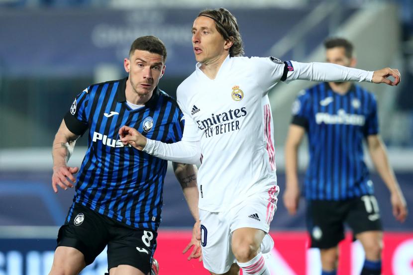 Pemain Atalanta Robin Gosens (kiri) berduel dengan pemain Real Madrid Luka Modric (kanan) pada pertandingan leg pertama babak 16 besar Liga Champions di Stadion Bergamo, Italia, Kamis (25/2)