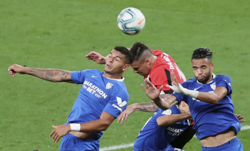 Pemain Athletic Bilbao Dani Garcia (tengah)  berebut bola dengan pemain Sevilla En-Nesyri (kanan) dalam pertandingan di San Mames Bilbao, Jumat (10/7) dini hari WIB. 