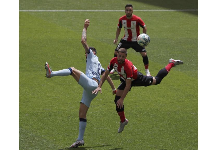 Pemain Athletic Bilbao Yerai Alvarez (kanan) berebut bola dengan gelandang Atletico Madrid Saul Niguez dalam pertandingan La Liga Spanyol di San Mames, Bilbao, Ahad (14/6)