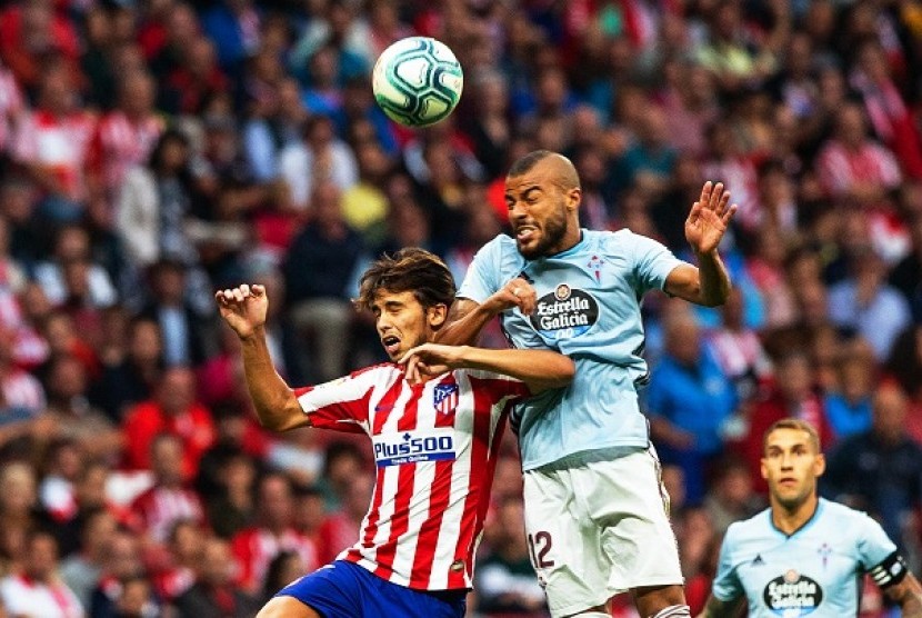 Pemain Atletico Madrid Joao Felix berebut bola dengan pemain Celta Vigo Rafinha dalam pertandingan lanjutan Liga Spanyol, Ahad (22/9) dini hari WIB.