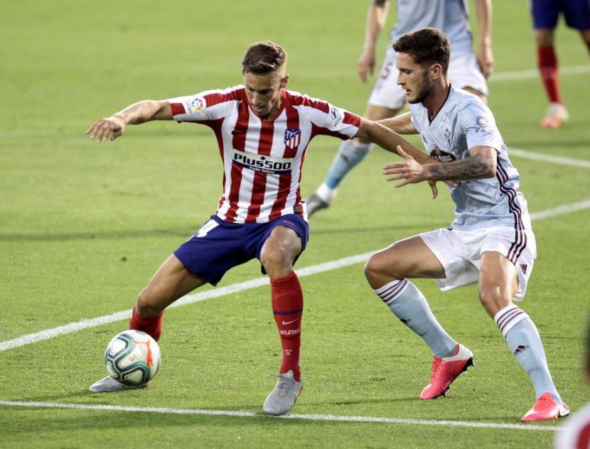 Pemain Atletico Madrid Marcos Llorente dijaga pemain Celta Vigo dalam pertandingan La Liga Spanyol, Rabu (8/7) WIB. Atletico ditahan imbang Celta 1-1.. 