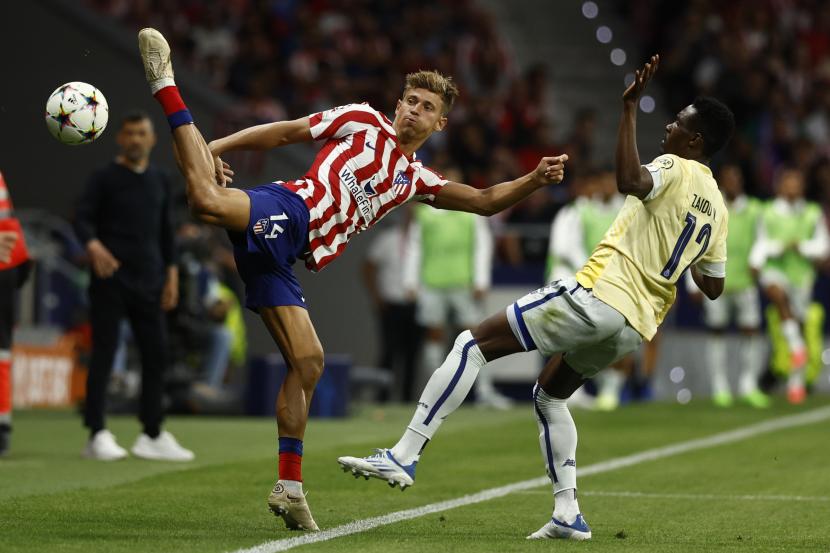  Pemain Atletico Madrid Marcos Llorente (kiri) berebut bola dengan pemain Porto Zaidu Sanusi pada pertandingan fase grup Liga Champions, Kamis (8/9/2022).