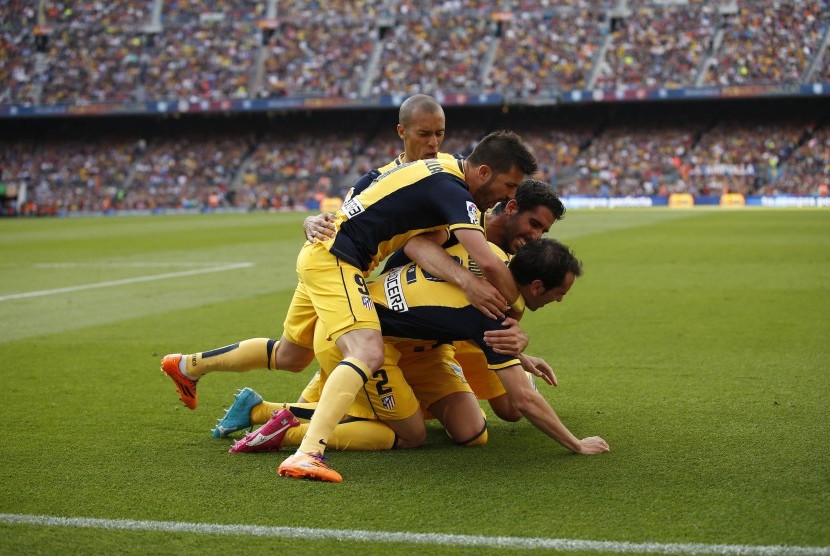 Pemain Atletico Madrid merayakan gol Diego Godin (bawah) saat menghadapi Barcelona di laga terakhir La Liga Spanyol di Camp Nou, Barcelona, Sabtu (17/5). 