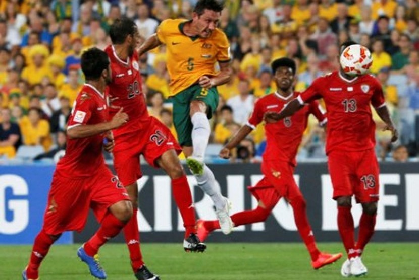 Pemain Australia Mark Milligan (tengah) menanduk bola di tengah kepungan pemain Oman dalam lanjutan Piala Asia 2015 Grup A, Selasa (13/1).