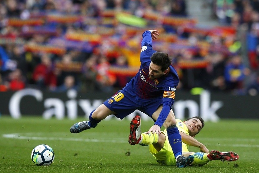   Pemain Barcelona Lionel Messi (kiri) saat berebut bola dengan pemain Getafe, Mauro Arambarri di Camp Nou, Ahad (11/2) waktu setempat 