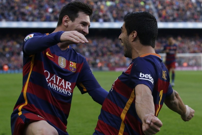 Pemain Barcelona Luis Suarez dan rekan setimnya Lionel Messi merayakan kemenangannya atas Atletico Madrid, Sabtu (30/1), di Camp Nou.