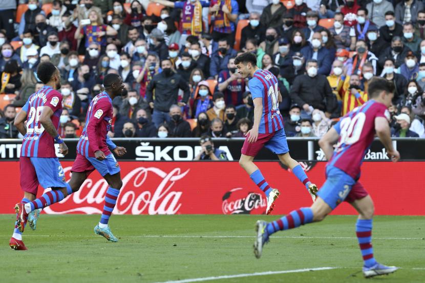 Pemain Barcelona Pedri, ke-3 dari kiri, merayakan setelah mencetak gol keempat timnya selama pertandingan sepak bola La Liga Spanyol antara Valencia dan Barcelona di stadion Mestalla di Valencia, Spanyol, Ahad, 20 Februari 2022.