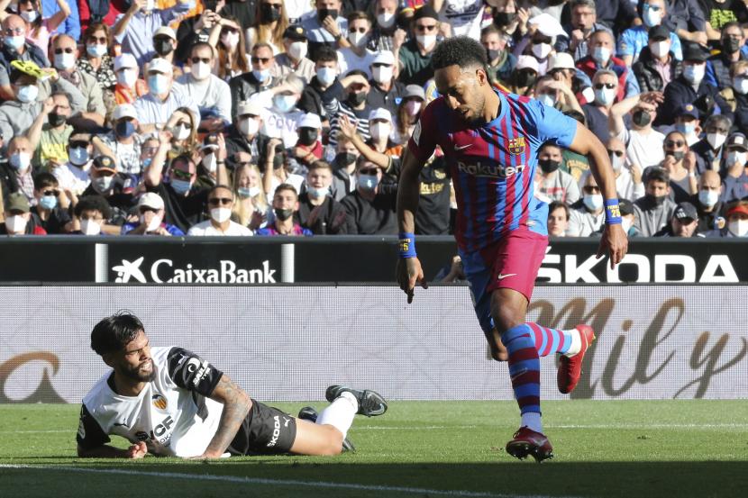 Striker Barcelona Pierre-Emerick Aubameyang (kanan) bereaksi ketika ia mencetak gol pembuka selama pertandingan sepak bola La Liga Spanyol antara Valencia dan Barcelona di Stadion Mestalla di Valencia, Spanyol, Ahad, 20 Februari 2022.