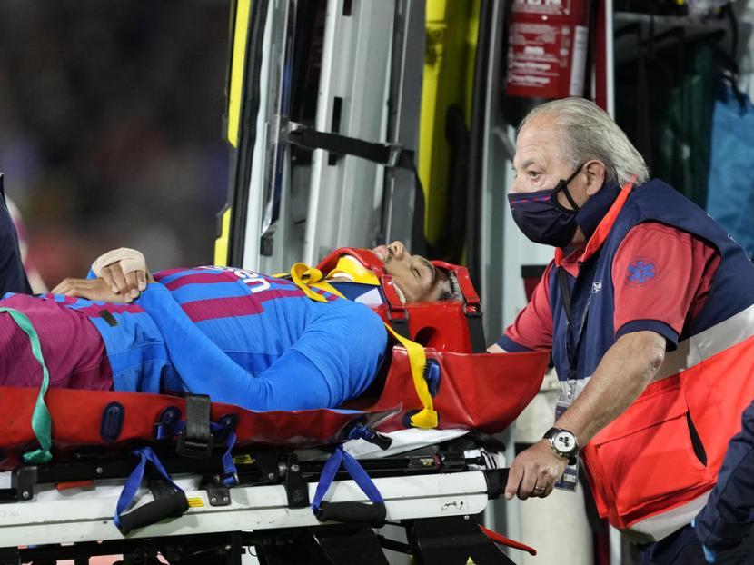 Pemain Barcelona Ronald Araujo diangkat ke ambulans setelah kolaps di lapangan.
