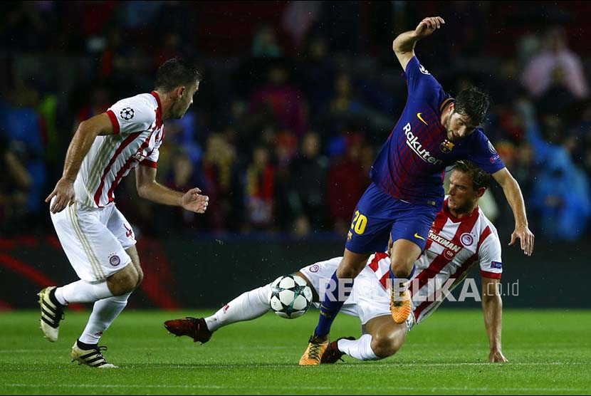 Pemain Barcelona Sergi Roberto diganjal pemain Olympiakos pada pertandingan Liga Champions Eropa Grup D di Stadion Camp Nou, Kamis (19/10) dini hari.