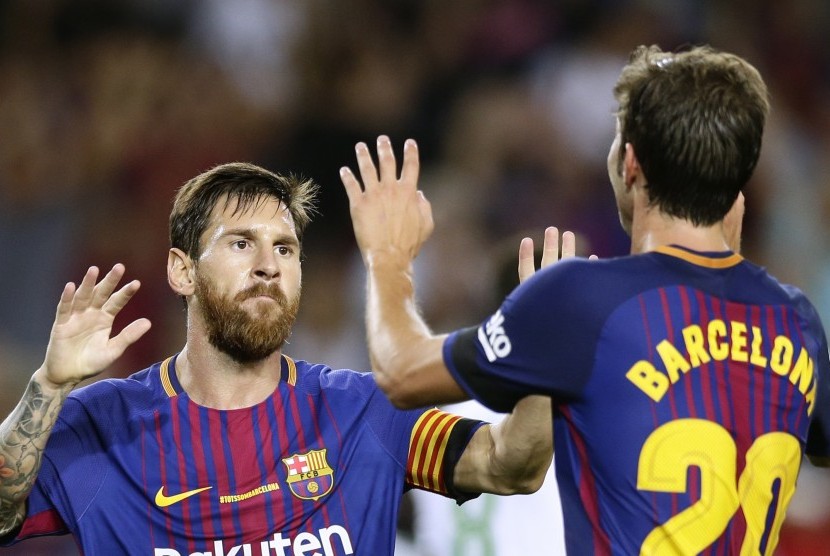  Pemain Barcelona Sergi Roberto (kanan) merayakan golnya dengan rekan timnya Lionel Messi dalam pertandingan La Liga melawan Real Betis di Camp Nou, Barcelona, (21/8).