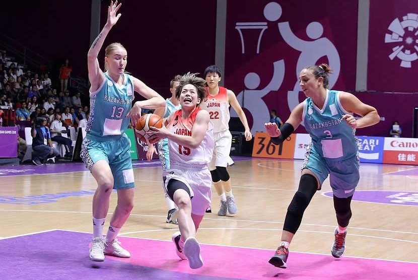 Pemain basket Jepang, Shiori Yasuma melakukan drive dikawal ketat oleh dua pemain Kazakhstan Anna Vinokurova (kiri) dan Zalina Kurazova (kanan) pada pertandingan Babak Perempatfinal Basket Putri Asian Games ke 18 di Hall Basket Senayan, Jakarta Minggu (26/8). 