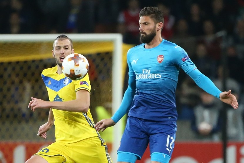 Pemain BATE Nemanja Milunovic (kiri) berusaha menghalau striker Arsenal Olivier Giroud (kanan) ketika kedua tim berhadapan pada penyisihan Grup H Liga Europa di Borisov, Belarusia, Jumat (29/9) dini hari WIB. 
