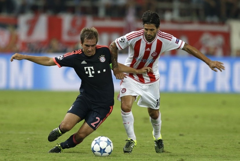 Pemain Bayern Muenchen, Phillip Lahm (kiri) dan pemain Olympiakos Alejandro Domininguez (kanan) berebut bola dalam lanjutan pertandingan Liga Champions