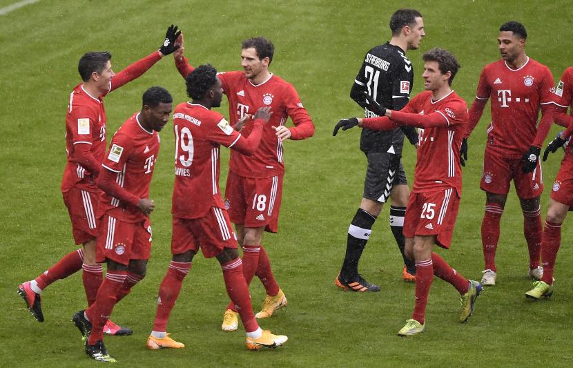 Pemain Bayern Muenchen Robert Lewandoski merayakan gol ke gawang Freiburg pada pertandingan Ahad (17/1).