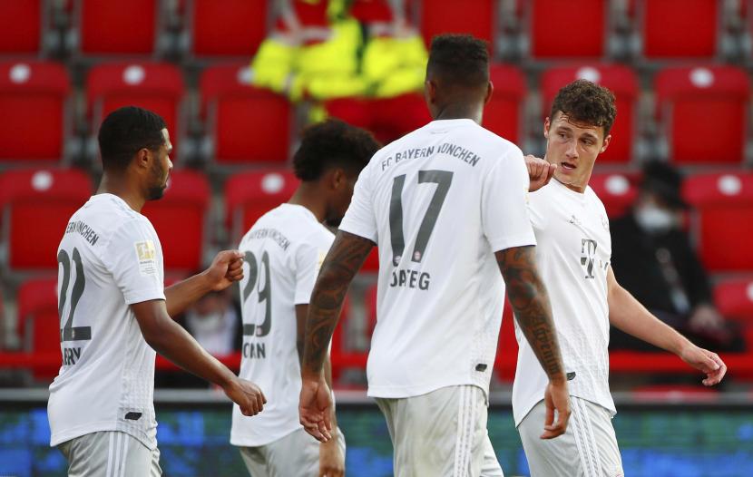 Pemain Bayern Muenchen Benjamin Pavard (kanan) merayakan gol kedua timnya selama pertandingan sepak bola Bundesliga Jerman antara Union Berlin dan Muenchen di Berlin, Jerman, Ahad (17/5). Dalam pertandingan tersebut Muenchen menang 2-0. Bundesliga Jerman menjadi liga sepak bola utama pertama di dunia yang melanjutkan setelah dihentikan dua bulan karena pandemi covid-19.  