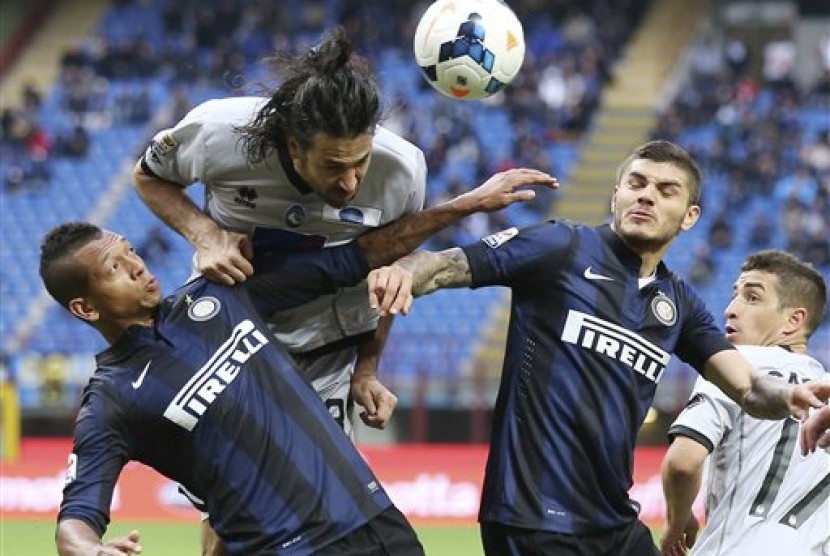 Pemain belakang Atalanta Mario Yepes berebut bola dengan pemain Inter Milan Fredy Guarin dan Mauro Icardi dalam pertandingan Liga Serie A, Ahad (23/14).