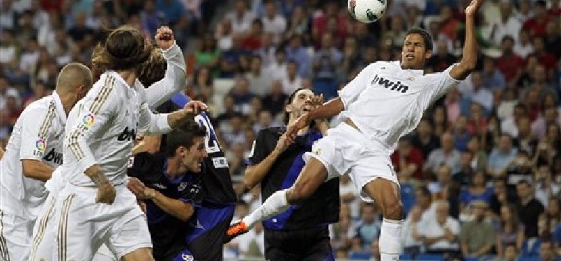 Pemain belakang Real Madrid dari Prancis, Raphael Varane (kanan), ketika menjebol gawang Rayo Vallecano di stadion Santiago Bernabeu, beberapa waktu lalu.