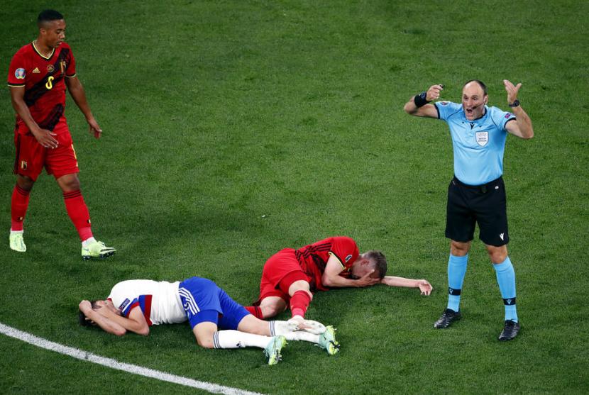 Pemain Belgia Timothy Castagne (kedua kanan) terbaring usai berbenturan di udara dengan pemain Rusia Daler Kuzyaev di Euro 2020.