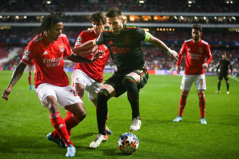  Pemain Benfica Valentino Lazaro (kiri) dan Paulo Bernardo beradu dengan pemain Ajax Dusan Tadic dalam laga leg pertama babak 16 besar Liga Champions 2021/2022, yang berlangsung di Estadio da Luz, Benfica, Portugal, Kamis (24/2) dini hari WIB. Ajax menahan imbang tuan rumah Benfica, 2-2.