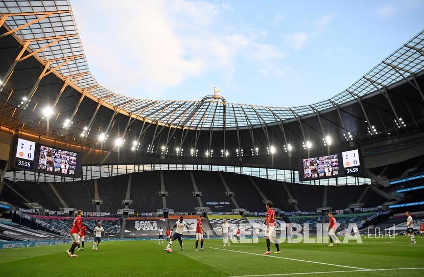 Pemain beraksi di depan tribun kosong selama pertandingan sepak bola Liga Primer Inggris antara Tottenham Hotspur dan Manchester United di Stadion Tottenham Hotspur di London, Inggris, Jumat (19/6/2020).