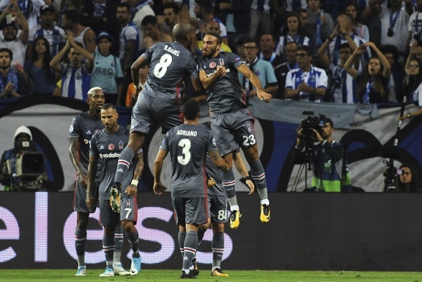 Pemain Besiktas Cenk Tosun (kanan) merayakan golnya ke gawang Porto di Liga Champions, Kamis (14/9) dini hari WIB.