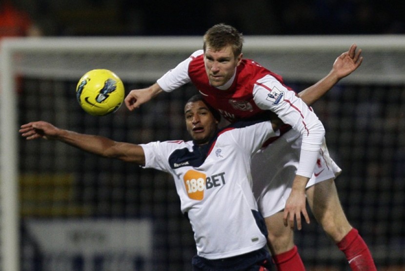  Pemain Bolton, David N'Gog (bawah) saat berebut bola dengan pemain belakang Arsenal Per Mertesacker dalam lanjutan liga Inggris di The Reebok Stadium, Bolton, Inggris, (1/2) 2012