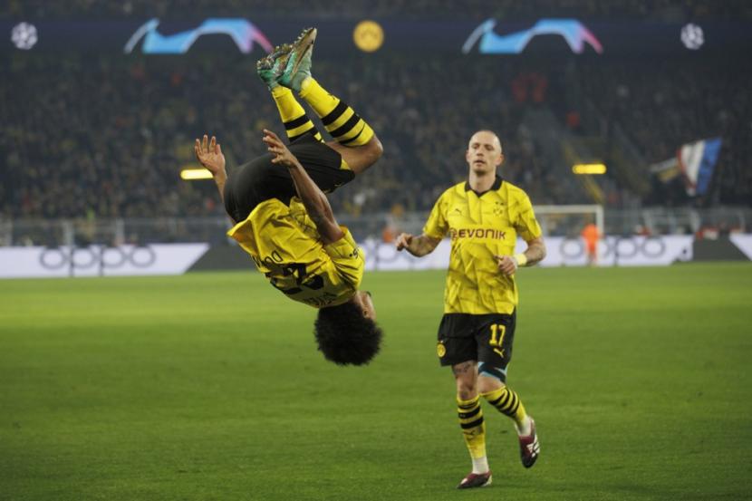Pemain Borussia Dortmund Karim Adeyemi melakukan gerakan salto saat merayakan gol ke gawang PSG dalam laga terakhir penyisihan Grup F Liga Champions, Kamis (14/12/2023) dini hari WIB.