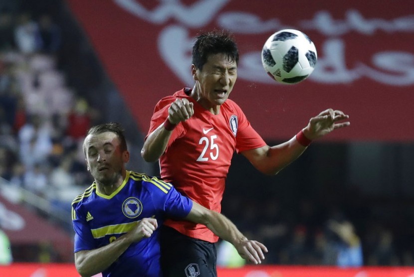 Pemain Bosnia, Edin Visca (kanan) berebut bola dengan pesepak bola Korea Selatan, Jung Woo-young, pada laga persahabatan di Seoul, Jumat (1/6). Visca mencetak tiga gol pada laga ini.